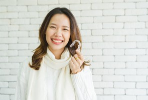 woman Invisalign brick wall